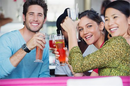 Portrait of friends toasting drinks in a restaurant Stock Photo - Premium Royalty-Free, Code: 6108-05874955