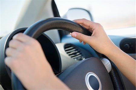 steering wheel - Close-up of a young woman's hand holding steering wheel Foto de stock - Sin royalties Premium, Código: 6108-05874925