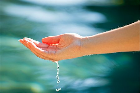 refreshed - Close-up of a man's hand touching the water of the swimming pool Foto de stock - Sin royalties Premium, Código: 6108-05875042