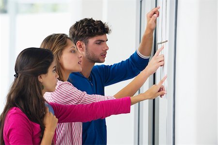 people looking at notice board - University students checking bulletin board for test result Foto de stock - Sin royalties Premium, Código: 6108-05875084