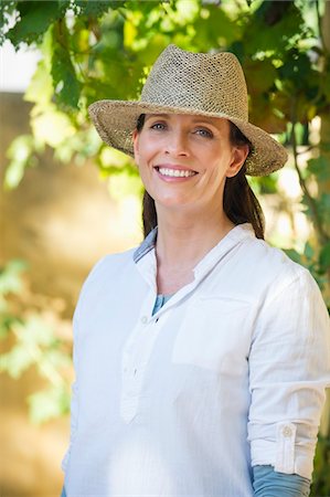 Portrait of a beautiful mature woman wearing hat and smiling Stock Photo - Premium Royalty-Free, Code: 6108-05875098