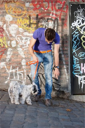 Man showing feces to his puppy, Paris, Ile-de-France, France Fotografie stock - Premium Royalty-Free, Codice: 6108-05875174