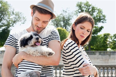 paris - Homme portant un chiot et souriant avec une femme à la recherche triste, Paris, Ile-de-France, France Photographie de stock - Premium Libres de Droits, Code: 6108-05875191