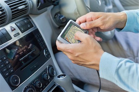 person in car interior - Close-up of human hand using GPS navigation system in car Stock Photo - Premium Royalty-Free, Code: 6108-05875115