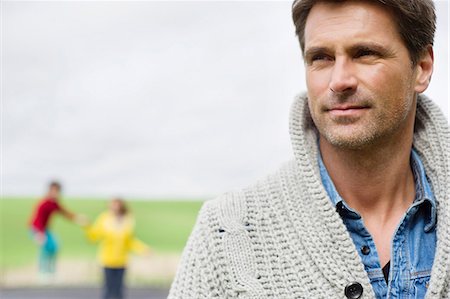 farms - Close-up of a man thinking with his son and wife in the background Stock Photo - Premium Royalty-Free, Code: 6108-06165995