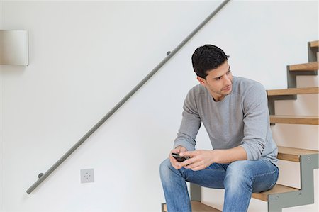 simsearch:6108-06166956,k - Man sitting on stairs using a mobile phone Stock Photo - Premium Royalty-Free, Code: 6108-06165998