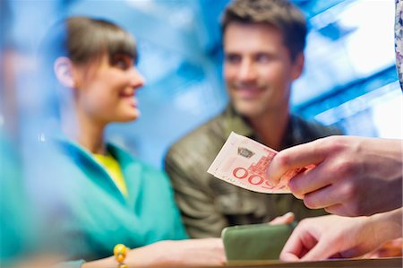 people give money to someone - Couple at bank counter Stock Photo - Premium Royalty-Free, Code: 6108-06166052