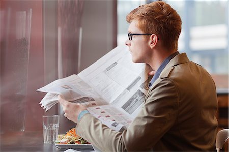 simsearch:6108-06166043,k - Man sitting in a restaurant and reading a newspaper Foto de stock - Sin royalties Premium, Código: 6108-06166092