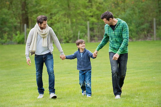 Boy walking with two men in a park Stock Photo - Premium Royalty-Free, Image code: 6108-06166003