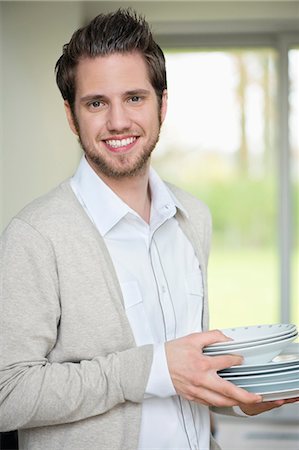 Portrait of a man carrying plates Stock Photo - Premium Royalty-Free, Code: 6108-06166271