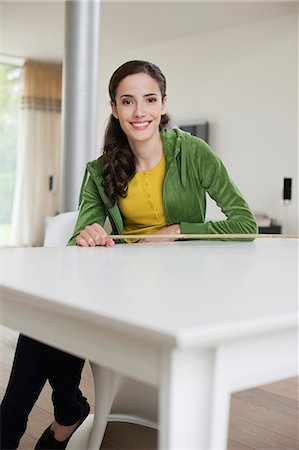 simsearch:6108-06167873,k - Happy woman sitting at a table Stock Photo - Premium Royalty-Free, Code: 6108-06166201