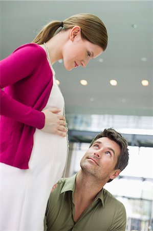 ponytail man - Man looking at a pregnant woman Stock Photo - Premium Royalty-Free, Code: 6108-06166395