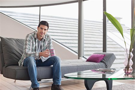 sofa on wooden floor - Homme assis sur un canapé et de boire du café Photographie de stock - Premium Libres de Droits, Code: 6108-06166318