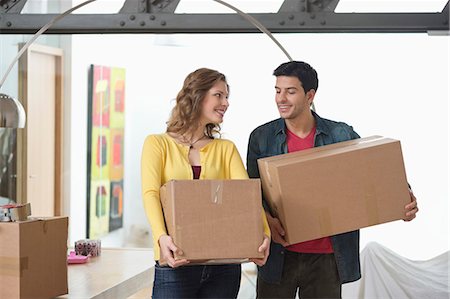 Couple carrying cardboard boxes and smiling Stock Photo - Premium Royalty-Free, Code: 6108-06166469