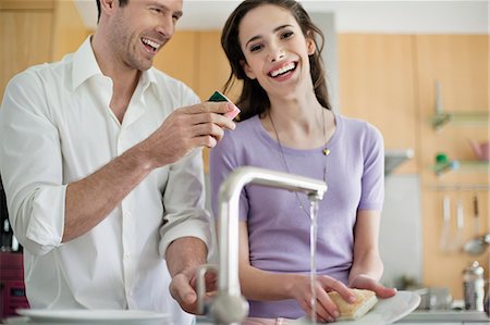 sponge and water - Woman washing utensils in the kitchen Stock Photo - Premium Royalty-Free, Code: 6108-06166430