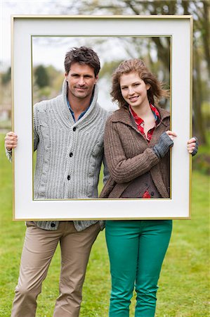 picture frames - Portrait of a couple holding a frame Stock Photo - Premium Royalty-Free, Code: 6108-06166569