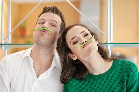 enthusiasm balance - Couple playing with green bean in the kitchen Stock Photo - Premium Royalty-Free, Code: 6108-06166677