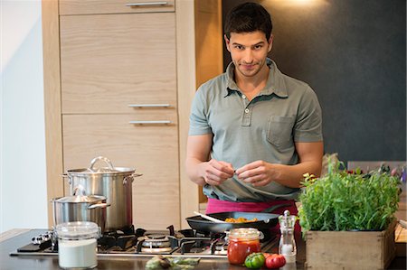 simsearch:6108-06166729,k - Man preparing food in the kitchen Foto de stock - Sin royalties Premium, Código: 6108-06166692