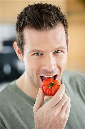 simsearch:6108-06166653,k - Man eating a tomato Foto de stock - Royalty Free Premium, Número: 6108-06166695