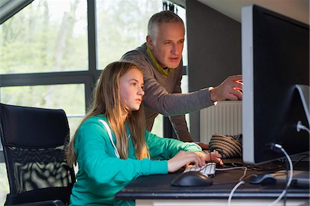 Jeune fille à l'aide d'un ordinateur avec son père à la maison Photographie de stock - Premium Libres de Droits, Code: 6108-06166610