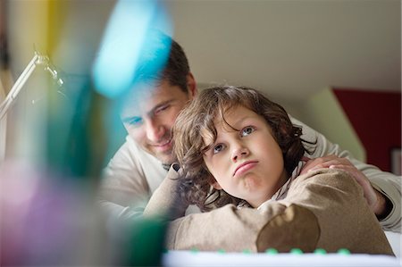 Boy thinking while studying with his father at home Foto de stock - Sin royalties Premium, Código: 6108-06166611