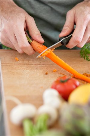 simsearch:6108-06166729,k - Man cutting carrot Foto de stock - Sin royalties Premium, Código: 6108-06166758