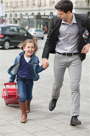 Girl pulling a trolley bag while running with her father Foto de stock - Sin royalties Premium, Código: 6108-06166796