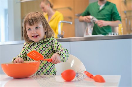 parent teen play - Cute little girl with slotted spoon and mixing bowl in the kitchen Stock Photo - Premium Royalty-Free, Code: 6108-06166733