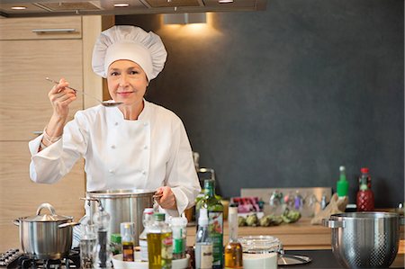 senior woman indoor portraits - Woman tasting food Stock Photo - Premium Royalty-Free, Code: 6108-06166731