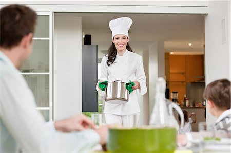 simsearch:6108-06167456,k - Woman serving food to her family Stock Photo - Premium Royalty-Free, Code: 6108-06166739