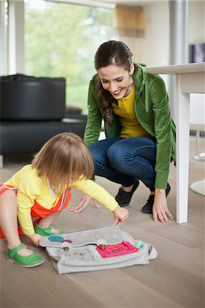 person crouching looking down - Woman helping her daughter to get ready for school Stock Photo - Premium Royalty-Free, Code: 6108-06166842