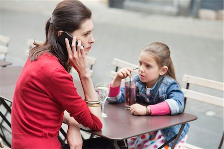 Woman with her daughter sitting in a cafe Stock Photo - Premium Royalty-Free, Code: 6108-06166870
