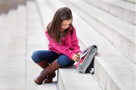 schoolgirl boot child - Girl opening her schoolbag Stock Photo - Premium Royalty-Free, Code: 6108-06166802