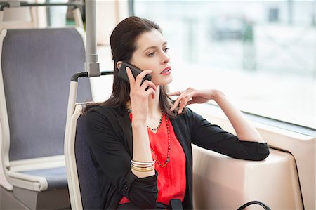 Woman traveling in a bus and talking on a mobile phone Stock Photo - Premium Royalty-Free, Code: 6108-06166967