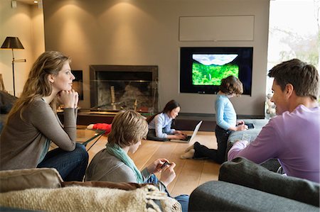 screen time - Famille à l'aide de gadgets électroniques dans une salle de séjour Photographie de stock - Premium Libres de Droits, Code: 6108-06166988