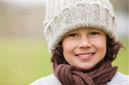 Portrait of a boy wearing a knit hat and smiling Stock Photo - Premium Royalty-Free, Code: 6108-06166999