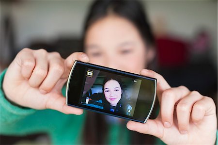 shower kid - Girl taking picture of herself with a mobile phone Foto de stock - Sin royalties Premium, Código: 6108-06166935