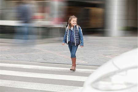 Schoolgirl crossing a road Stock Photo - Premium Royalty-Free, Code: 6108-06167048