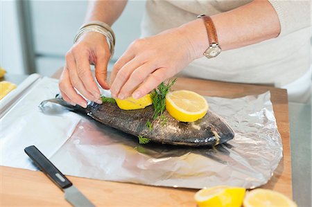 Elderly woman preparing seafood in a kitchen Foto de stock - Sin royalties Premium, Código: 6108-06167090