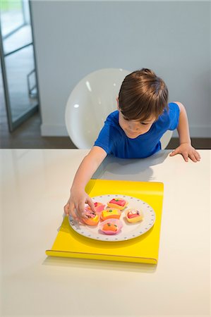 simsearch:6108-06167275,k - Boy picking a cup cake from plate Foto de stock - Sin royalties Premium, Código: 6108-06167006