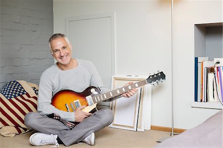 eye contact man portrait - Portrait of a happy man playing a guitar Stock Photo - Premium Royalty-Free, Code: 6108-06167162