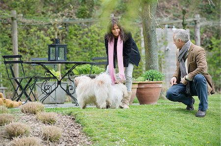 fun animals - Couple playing with their pets in a garden Stock Photo - Premium Royalty-Free, Code: 6108-06167165