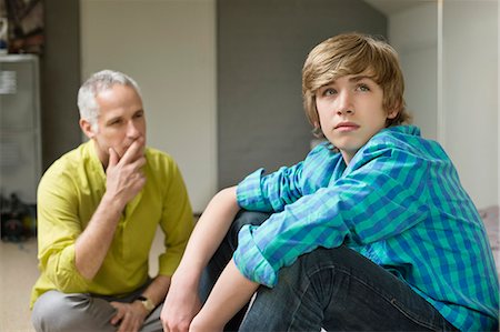 relationship problem - Man sitting with his son looking upset Stock Photo - Premium Royalty-Free, Code: 6108-06167191