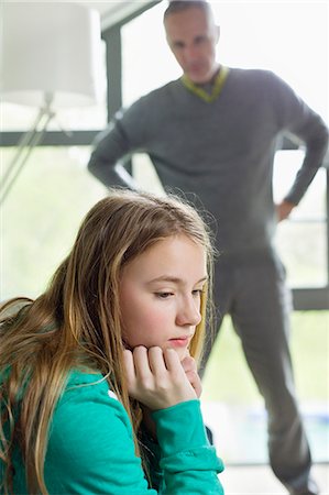 Girl looking upset with her father standing beside her Stock Photo - Premium Royalty-Free, Code: 6108-06167243