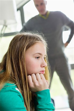 sad 12 year old girl - Girl looking upset with her father standing beside her Stock Photo - Premium Royalty-Free, Code: 6108-06167245