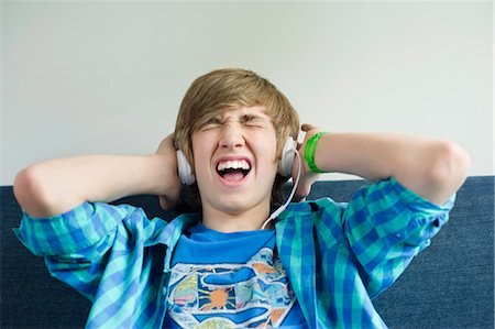 enjoy music with headphone - Teenage boy listening to music and looking excited Stock Photo - Premium Royalty-Free, Code: 6108-06167270