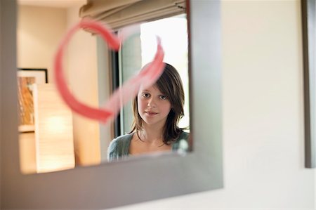 simsearch:6108-06167259,k - Girl looking at reflection in mirror decorated with heart shape Stock Photo - Premium Royalty-Free, Code: 6108-06167285