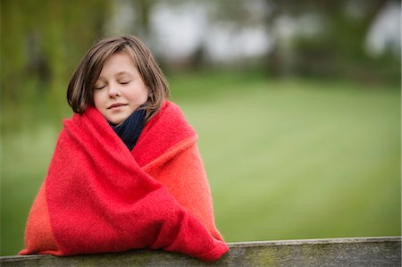 Fille enveloppée dans une couverture avec les yeux fermés dans une batterie de serveurs Photographie de stock - Premium Libres de Droits, Code: 6108-06167360