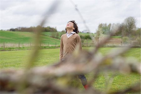 daydreaming in a field - Boy daydreaming in a field Stock Photo - Premium Royalty-Free, Code: 6108-06167373