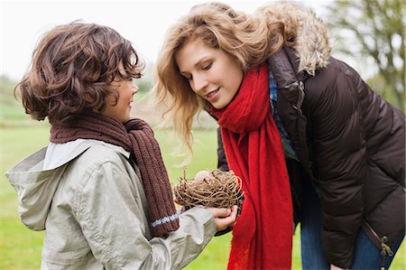 Boy showing eggs in nest to his mother Stock Photo - Premium Royalty-Free, Code: 6108-06167381